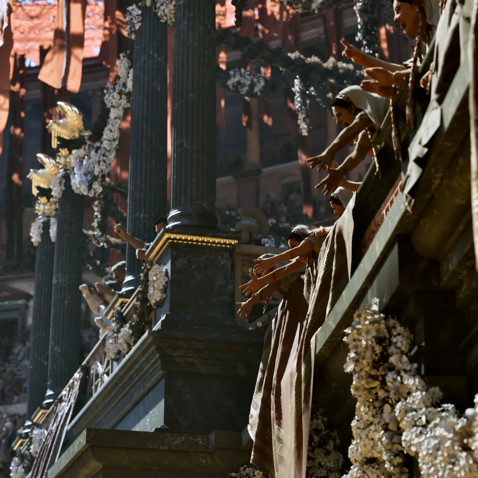 Women in ceremonial dress leaning over a garlanded balustrade on the podium above the arena, sunlight across the marble.