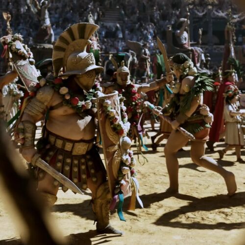 Gladiators and attendants cross the sand of the Colosseum in the pompa, seen from behind the animal cages of the hypogeum, Rome 192 AD